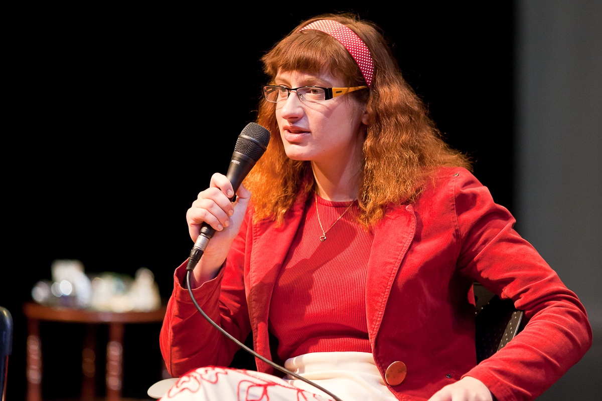 Image of Jana Mazurkiewicz Meisarosh, talking into a microphone